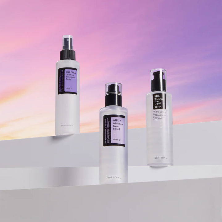 Collection of COSRX skincare products including AHA BHA Clarifying Treatment Toner, cleansers, pads, and patches on white display blocks