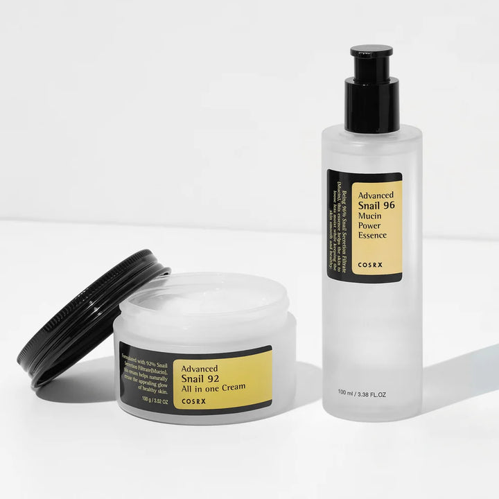 COSRX Snail Duo Bundle with open Snail 92 Cream jar and Snail 96 Essence bottle on a white background.