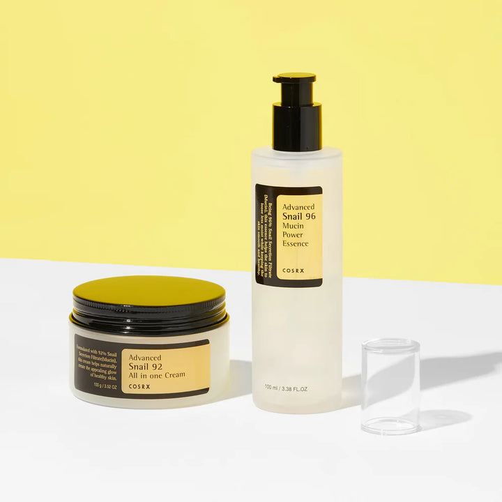 COSRX Advanced Snail 92 Cream and Snail 96 Essence displayed on a yellow background.